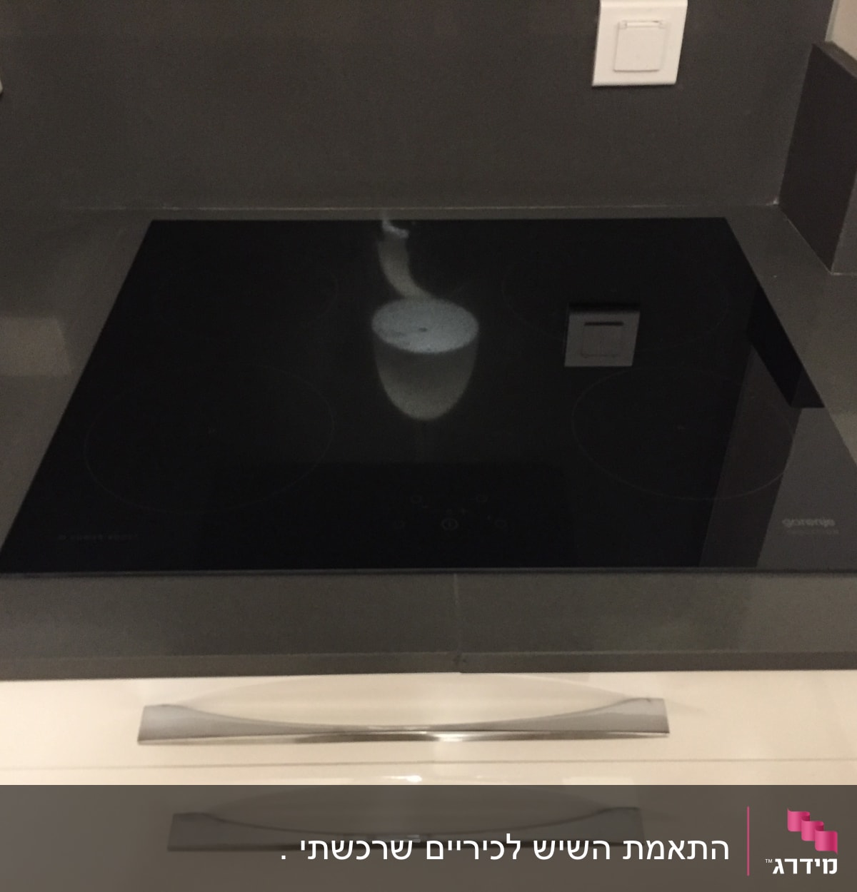 כיריים חשמליות על משטח שיש אפור במטבח מודרני